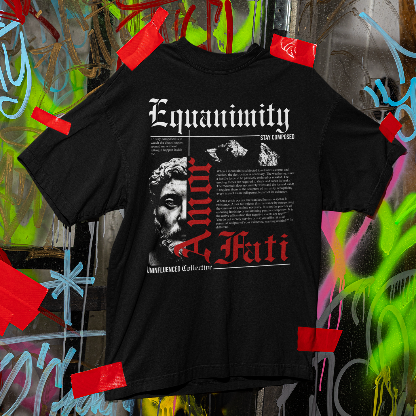 Black t-shirt with graphic design and text on a graffiti-covered wall background