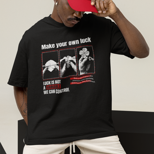 Man wearing a black t-shirt with a graphic design and text, holding a red cap.