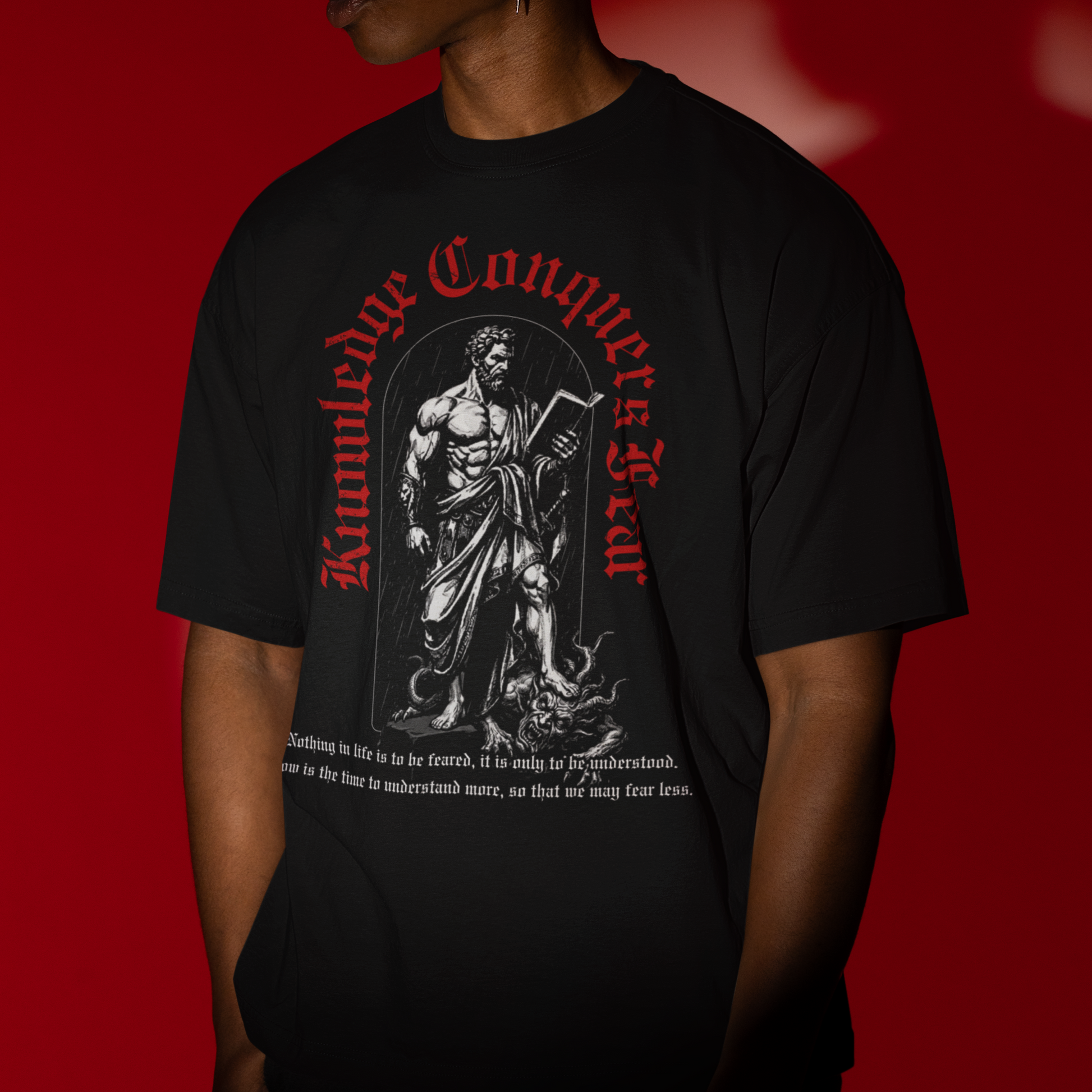 Person wearing a black t-shirt with graphic design and text against a red background